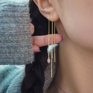 Detailed view of long gold S925 silver threader earrings with pink marquise gemstone
