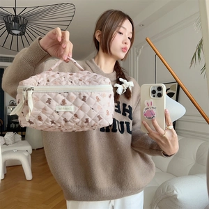 Detail of pink quilted makeup bag with cute bear print and sturdy top handle