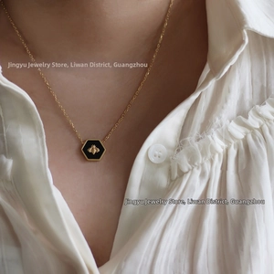 Close-up of vintage hexagonal bee pendant necklace in gold-plated stainless steel