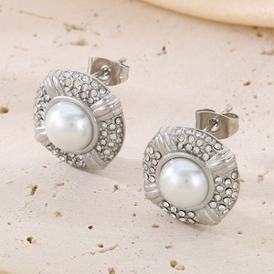 Macro shot of silver oval earrings with center pearl and surround rhinestones detail