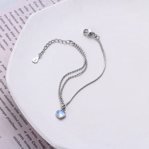 Macro shot of S925 silver double-layer bracelet with heart moonstone on white tray