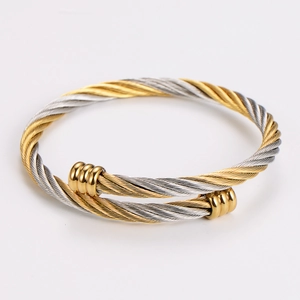 Detail of two-tone braided cable cuff bracelet with gold and silver metallic wire