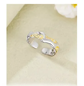 Detail of 925 silver adjustable ring with wavy gold texture and micro-set crystals