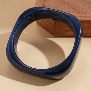 Close-up of deep blue marble pattern resin bangle with a unique geometric design