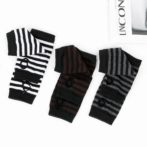 Detailed close-up of striped knit fingerless gloves with thumb holes in three color patterns