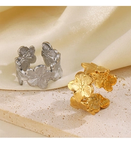 Macro detail of gold and silver flower rings on stone base with adjustable open band design