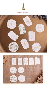 Detailed view of gold foil wedding gift tags with Eiffel Tower pendant on wooden surface