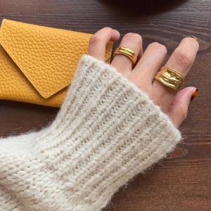 Macro shot of minimalist gold double-layer and wavy textured rings on hand