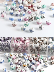 Macro shot of assorted round ceramic beads with floral patterns in a clear storage case