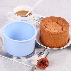 Detailed view of a blue round silicone cake mold on a marble table with a fresh cake