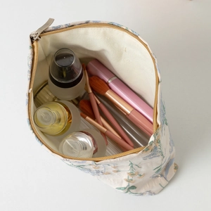 Dettaglio che mostra la grande capacità della borsa cosmetica floreale con vari trucchi