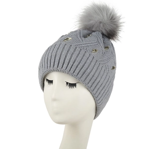 Grey knit beanie with fleece lining, gold stud accents and a large faux fur pom-pom