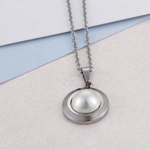 Elegant 18k gold plated round pearl pendant necklace on a bicolored background