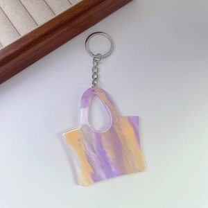 Detail of purple and yellow marble pattern acrylic bag keychain with silver ring