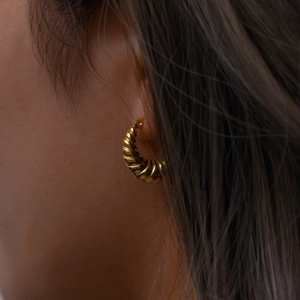 Detailed view of 18K gold plated croissant hoop earring on model with spiral texture