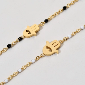 Detailed close-up of gold Hamsa charm with evil eye and black white enamel beads