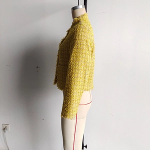 Vue macro du tissu tweed jaune avec bords à franges et détails de texture tissée