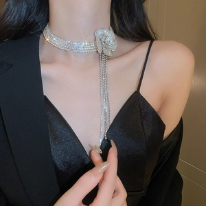 Dettaglio macro del choker a fiore d'argento con nappe di diamanti scintillanti su modella