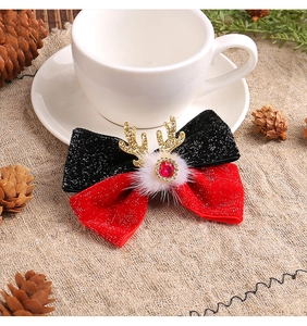 Detailed view of 3D Christmas antler hair clip with velvet bow and white pompom