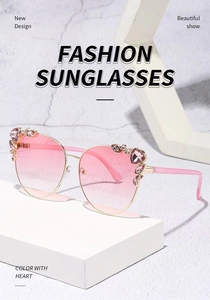 Detail of cat-eye sunglasses with pink gradient lenses and rhinestone-encrusted gold frame