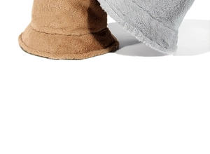 Detail shot of the thick plush faux rabbit fur texture on brown and grey bucket hats