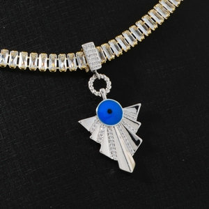 Macro shot of hip hop pendant with blue evil eye and zircons on gold silver chain