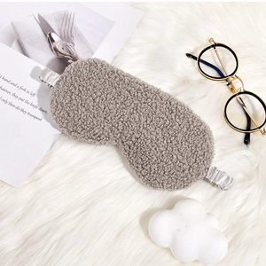Close-up of grey plush teddy fur sleep mask with a silky elastic silver-grey head strap