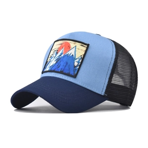 Detail of mountain embroidery patch on mesh trucker hat with breathable blue side panels