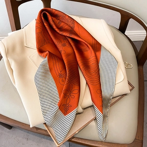 Close-up of caramel silk scarf with polka dots draped on a beige blazer jacket