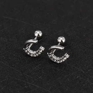 Macro view of C-shaped silver screw-back cartilage stud with sparkling cubic zirconia