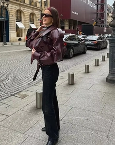 Street style shot of a vintage burgundy leather motorcycle jacket with lapels