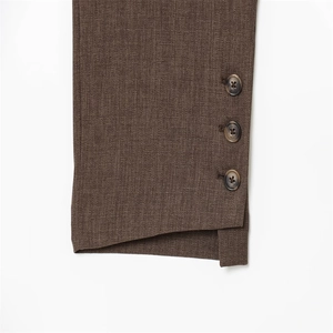 Détail de l'ourlet de pantalon marron foncé avec trois boutons écaille de tortue