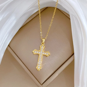 Luxurious gold cross necklace with sparkling zircons displayed on elegant white silk