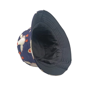 Détail d'un chapeau bob enfant bleu foncé avec imprimé oies blanches et tissu en coton durable