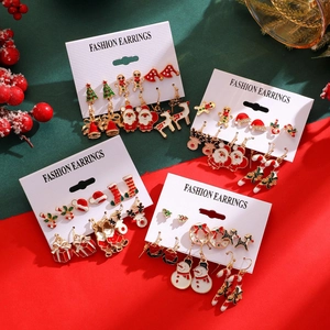 Close-up of colorful Christmas earrings set with Santa, reindeer and tree motifs