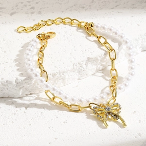 Detail view of double-layer bracelet with pearls, gold chain and rhinestone bow charm