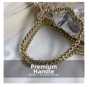 Detail of golden bead handle and metallic cage frame on a vintage luxury handbag