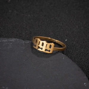Macro shot of gold stainless steel ring with 999 number design on dark stone base