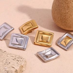 Macro shot of geometric rectangular stud earrings in gold and silver stainless steel