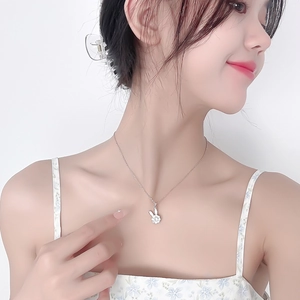 Detail of a rotating rabbit necklace with sparkling white zircons on a silver chain