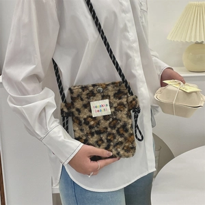Close-up of leopard print plush crossbody bag with rainbow label and rope strap