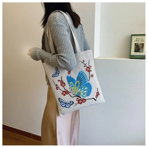 Detailed fabric texture of canvas tote bag featuring blue butterfly and floral prints