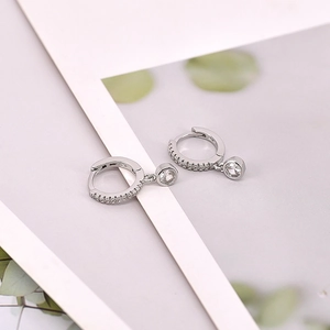 Macro shot of silver S925 earrings with small pave zircons and a round pendant