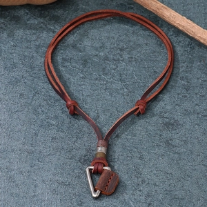 Choker doppio in pelle marrone con ciondolo a triangolo argento su sfondo pietra