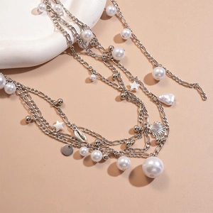 Detail of multi-layer waist chain with imitation pearls and silver sea shell pendants