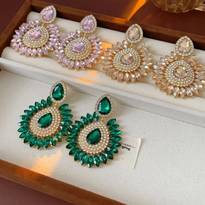 Detailed view of teardrop crystal flower earrings in pink, champagne, and green colors
