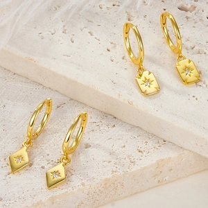 Detailed shot of S925 silver gold earrings with star-engraved rectangular pendants