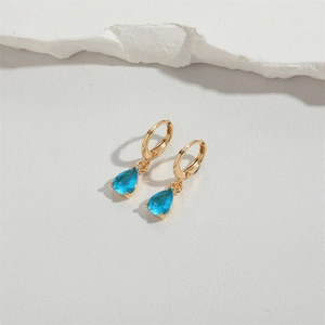 Macro detail of light blue water drop earrings with elegant golden hook finish