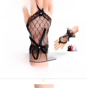 Close-up of black lace fingerless gloves with mesh ruffles and a satin ribbon bow