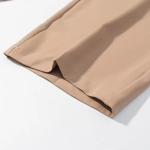 Close-up of khaki trousers cuff showing high-density woven fabric and double-stitched seams